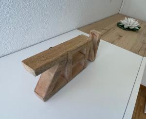 una panca di legno seduta sopra un tavolo di JARDINS DE RAMEL – APPT 2106*** - CURE/SKI WIFI a Luchon