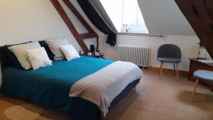 um quarto com uma cama, uma cadeira e uma janela em Jules Verne em Amiens