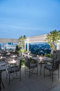 un patio con mesas y sillas y vistas a la ciudad en The Raintree, St. Mary’s Road, en Chennai