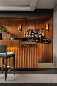 a kitchen with wooden cabinets and a counter with a bar at The Raintree, St. Mary’s Road in Chennai