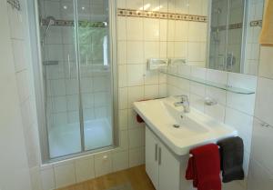 a white bathroom with a sink and a shower at Haus am Bach in Bad Wörishofen