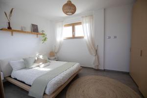 sypialnia z łóżkiem z białą pościelą i oknem w obiekcie Sundinia Home, Vista sul Mare w mieście Porto Torres
