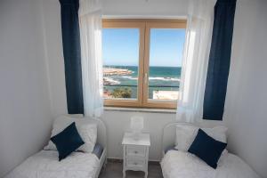 Pokój z 2 łóżkami i oknem z widokiem na ocean w obiekcie Sundinia Home, Vista sul Mare w mieście Porto Torres