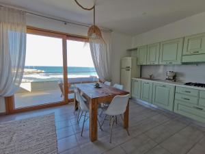 kuchnia ze stołem i widokiem na ocean w obiekcie Sundinia Home, Vista sul Mare w mieście Porto Torres