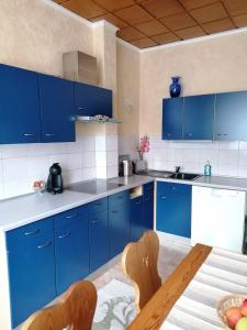 uma cozinha azul com uma mesa e armários azuis em Schöne Wohnung im Herzen von Burgstädt em Burgstaedt