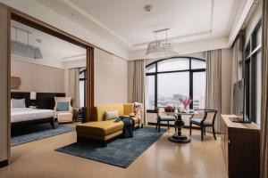 a hotel room with a bed and a living room at The Raintree, St. Mary’s Road in Chennai