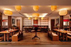 a restaurant with tables and chairs and chandeliers at The Raintree, St. Mary’s Road in Chennai