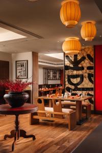 a restaurant with a vase of flowers on a table at The Raintree, St. Mary’s Road in Chennai
