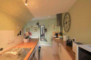 a kitchen with a large clock on the wall at King Street Apartment in Inverness
