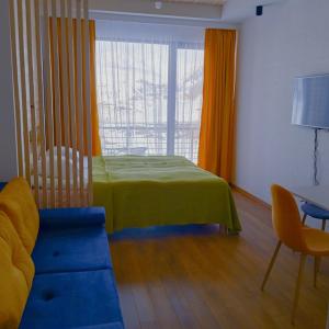 a room with a bed and a couch and a window at Roshka Apartment 307 in Gudauri