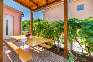 ファジャナにあるModern Holiday Home with pool & 4 bikes, near centerのパティオ(テーブル、ベンチ、ブドウ付)