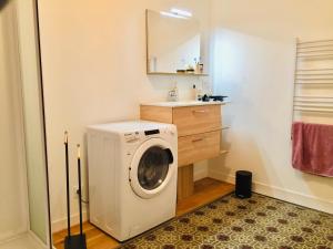 a washing machine in a bathroom with a sink at Chaleureux et spacieux appartement de centre-ville - Lit King Size - NETFLIX in Cherbourg en Cotentin