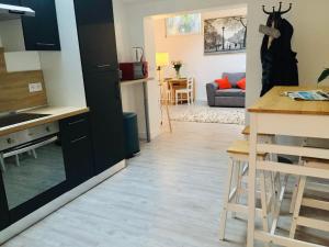 a kitchen with black cabinets and a dining room at Chaleureux et spacieux appartement de centre-ville - Lit King Size - NETFLIX in Cherbourg en Cotentin