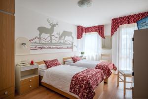 a bedroom with a bed and a dresser at Hotel Europa in San Martino di Castrozza