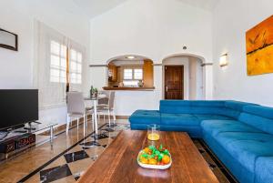 プラヤ・ブランカにあるFarolesのリビングルーム(青いソファ、テーブル付)
