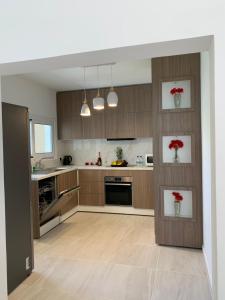 a kitchen with wooden cabinets and red flowers on the wall at SUNCITY in Limassol