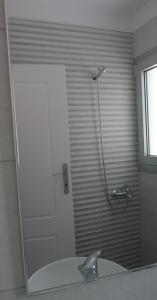 a bathroom with a shower with a sink and a mirror at Proimos Apartments in Gerani +44 photos