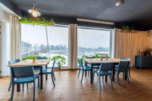 a dining room with tables and chairs and a large window at Hotel Przystań WARMIA in Olsztyn