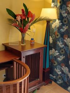 a vase of flowers on a table next to a lamp at STUDIO 1015 in Sainte-Anne