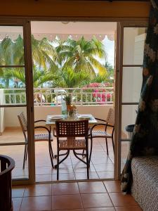 a dining room with a table and chairs on a balcony at STUDIO 1015 in Sainte-Anne