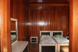 a bedroom with a bed in a wooden wall at Hotel Villa Oasis in Kobuleti