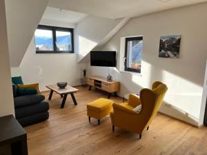 a living room with a couch and a tv at Neues Traunsee Apartment Altmünster in Altmünster