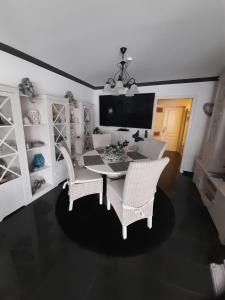 une salle à manger avec une table et des chaises blanches dans l'établissement Ferienwohnung Wührmann, à Wenkendorf