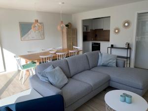 uma sala de estar com um sofá e uma sala de jantar em Residentie Hippocampe em Wenduine