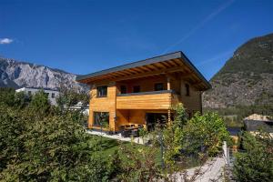 a wooden house on a hill with mountains in the background at das Blockhittle in Sautens