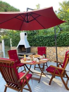 une terrasse avec une table, des chaises et un parasol dans l'établissement Apartman Pirol - Pure Enjoyment & Relaxation, à Poreč