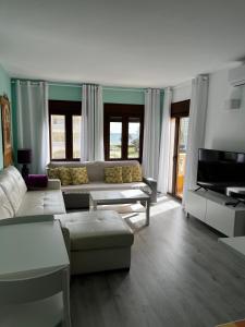 a living room with a couch and a television at Apartamentos Roquetas Beach in Roquetas de Mar