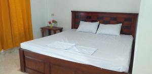 - une chambre avec un grand lit et une tête de lit en bois dans l'établissement Toba Boi, à Tuk Tuk