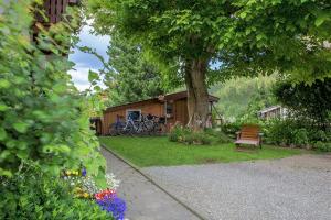 una casa con un banco y un árbol en un patio en Ferienwohnung Dressler, en Pfronten