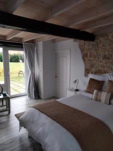 a bedroom with a large bed with a stone wall at La buganvilla en Udías in Udias