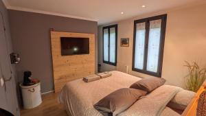 - une chambre avec un lit et une télévision à écran plat dans l'établissement Chambres privées proche DISNEY Parcs, à Chanteloup-en-Brie