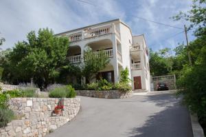 Casa blanca con pared de piedra y entrada en SEA VIEW apartments, en Klenovica