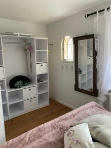 1 dormitorio con estantes blancos y espejo en Kleines, feines Domizil - 500m von der Strandpromenade, en Dahme