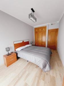 a bedroom with a large bed and a night stand at Apartamento La Muralla in Baena