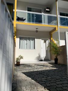 a house with a balcony and a stone walkway at Lindo Loft completo perto de cachoeira in Guapimirim