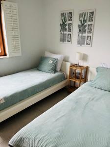 - 2 lits installés l'un à côté de l'autre dans une chambre dans l'établissement Duinenzicht II De Haan, au Coq