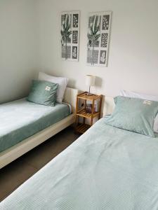 a bedroom with two beds and a side table at Duinenzicht II De Haan in De Haan