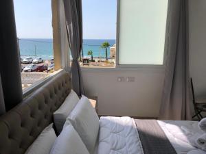 een slaapkamer met een bed en uitzicht op het strand bij Hotel Room Service in Bat Yam
