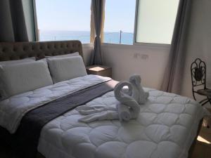 um quarto com uma cama com um animal de toalha em Hotel Room Service em Bat Yam