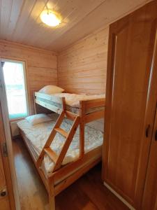 sypialnia z 2 łóżkami piętrowymi w drewnianym domku w obiekcie Panorama Blue Apartments w mieście Kilpisjärvi