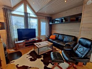 a living room with a couch and a tv at Panorama Blue Apartments in Kilpisjärvi