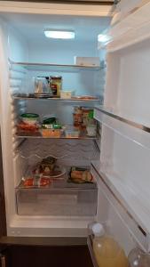 a refrigerator with its door open with food inside at Ferienwohnung, Monteurwohnung in Scheidegg