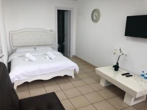 a bedroom with a white bed and a table at Sea Line Hotel From R&A Group in Bat Yam