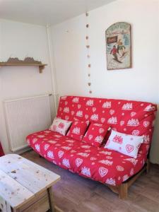 een rode bank in een woonkamer met een tafel bij Haut Alpin Superdévoluy in Superdevoluy