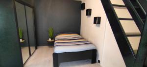 ein kleines Zimmer mit einer Treppe und einem Bett darin in der Unterkunft GO TO LUX Logement Entier [Parking Gratuit] in Algrange