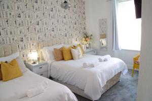a bedroom with two beds and a wall with photographs at St Edmunds Guest House in Paignton
